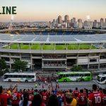 Solar-powered stadium with fans arriving by electric transit, illustrating environmental sustainability in football
